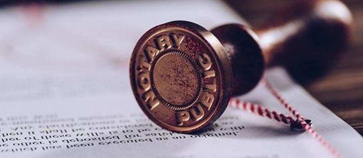 Brass notary public stamp resting on a document